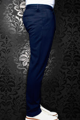 Men's navy pants shown from the side, with belt loops and a buttoned back welt pocket by Au Noir