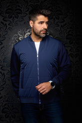 Au Noir men's navy blue quilted bomber jacket zipped on model, with ribbed collar, cuffs, and hem, front view