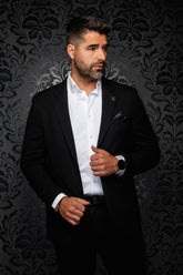 Au Noir men's black blazer with notched lapels, chest pocket, and small lapel pin shown from the front