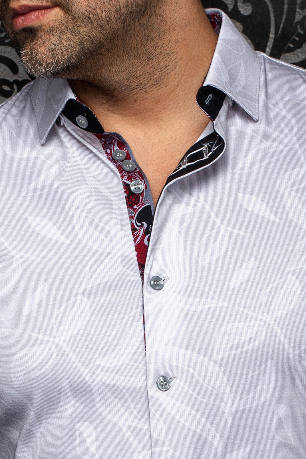 Col de chemise blanche à feuilles, boutons gris et patte intérieure rouge et noire pour homme par Au Noir, en gros plan