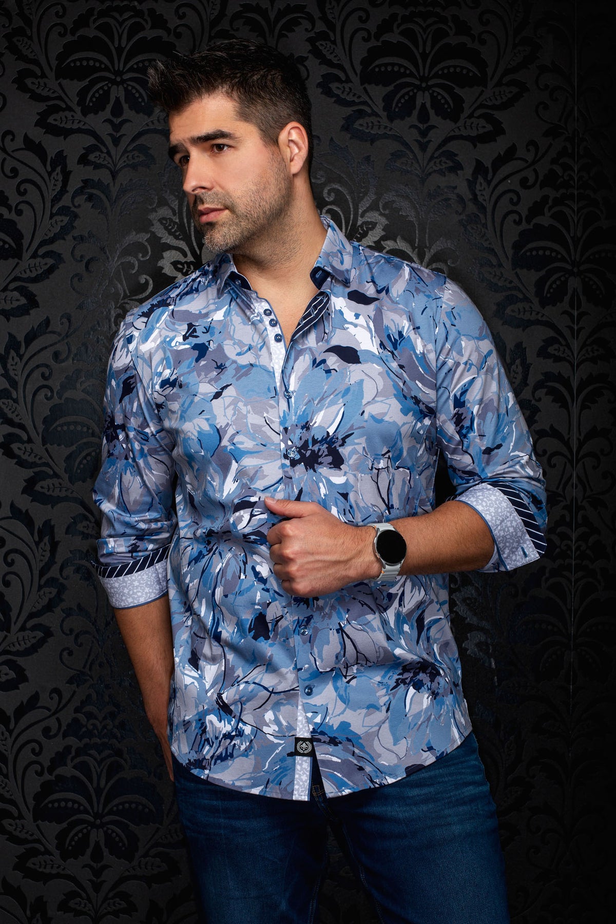 Front model view of men's light blue floral button-up shirt with rolled contrast cuffs and curved hem by Au Noir