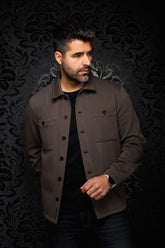Front model view of men's brown overshirt with shirt collar, black buttons, and chest pockets by Au Noir