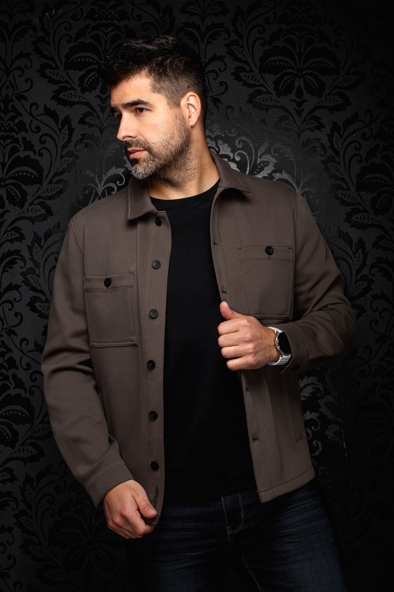 Men's angled model view of a brown button-front overshirt with chest pockets and black buttons, side view by Au Noir