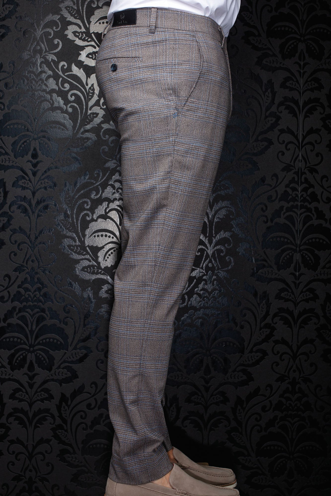 Au Noir men's brown plaid pants shown from the side, with buttoned back pocket and black waistband label