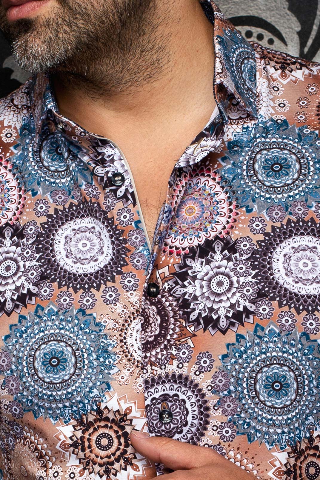 Au Noir men's tan printed shirt collar and black button placket with teal and white medallion motifs, close-up