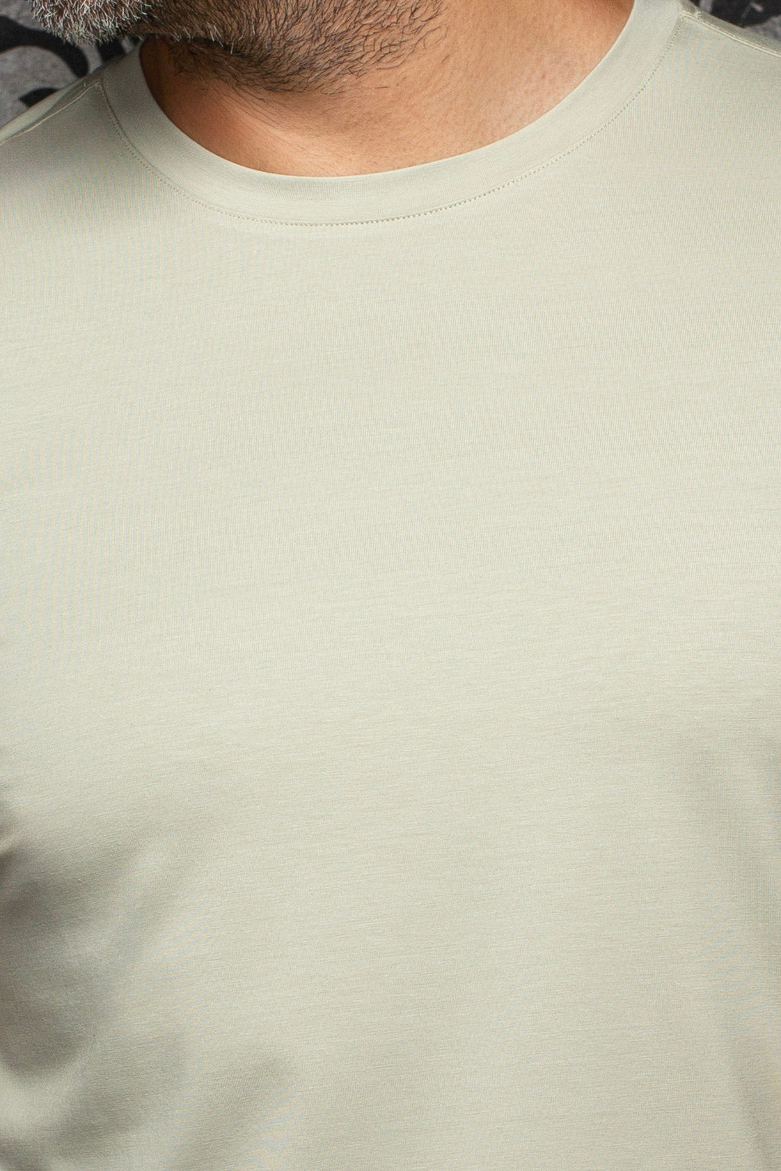Au Noir men's pale sage green crewneck Short-sleeve T-Shirt showing ribbed collar and fine jersey texture, close-up