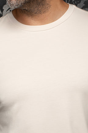 Au Noir men's cream crewneck Short-sleeve T-Shirt collar showing smooth knit fabric and tonal stitching, close-up