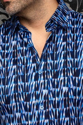 Au Noir men's blue abstract print button-up shirt showing the spread collar and blue buttons, close-up