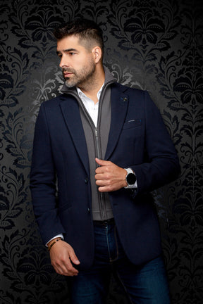 Men's slight side view of a navy textured blazer with a visible gray zip-front inner layer by Au Noir