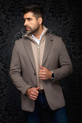 Men's angled front view of a taupe textured blazer with notch lapels, brown buttons and lapel pin by Au Noir