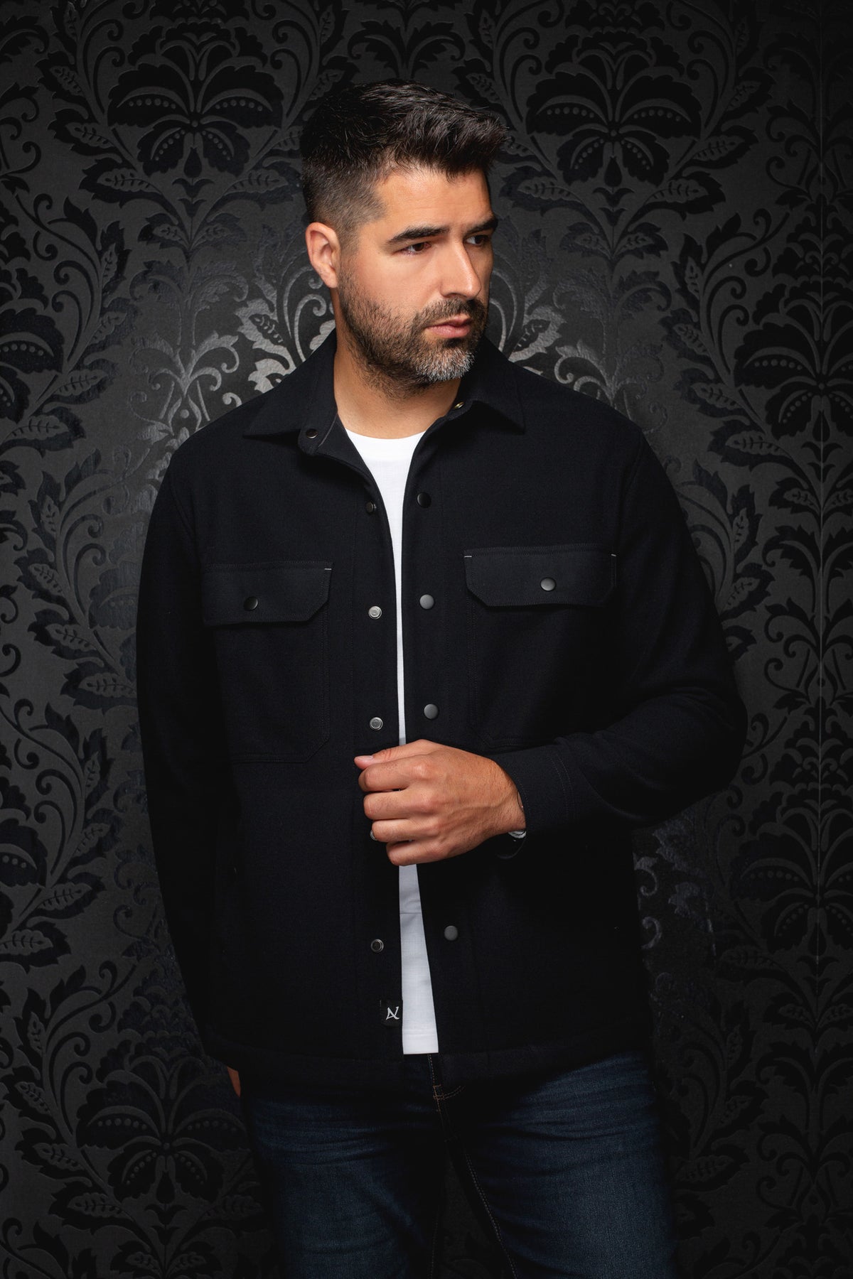 Men's black overshirt front view with snap closure and two flap chest pockets on model by Au Noir