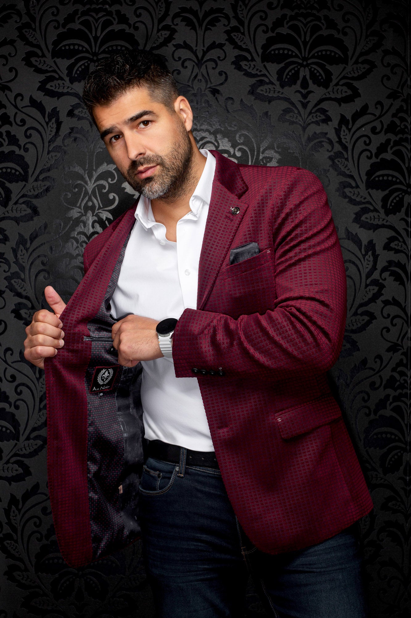 Men's angled view of burgundy micro-check blazer opened to show dark patterned lining and label, detail view by Au Noir
