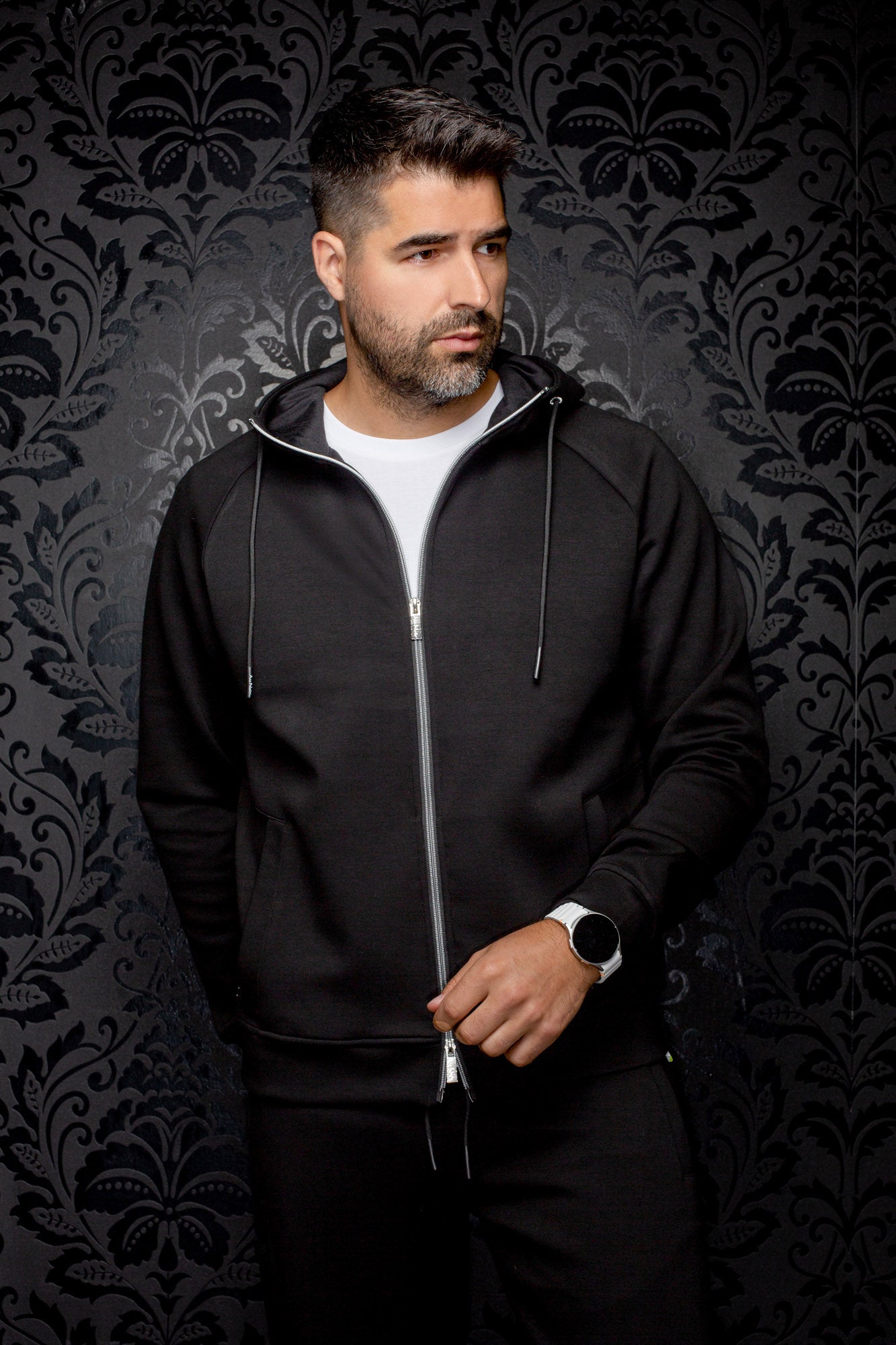 Au Noir men's black hooded zip sport jacket with silver zipper, drawstrings, and hand pockets shown from the front