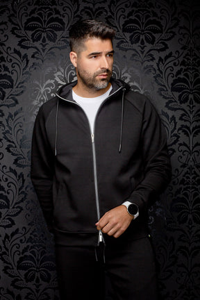 Au Noir men's black hooded zip sport jacket with silver zipper, drawstrings, and hand pockets shown from the front
