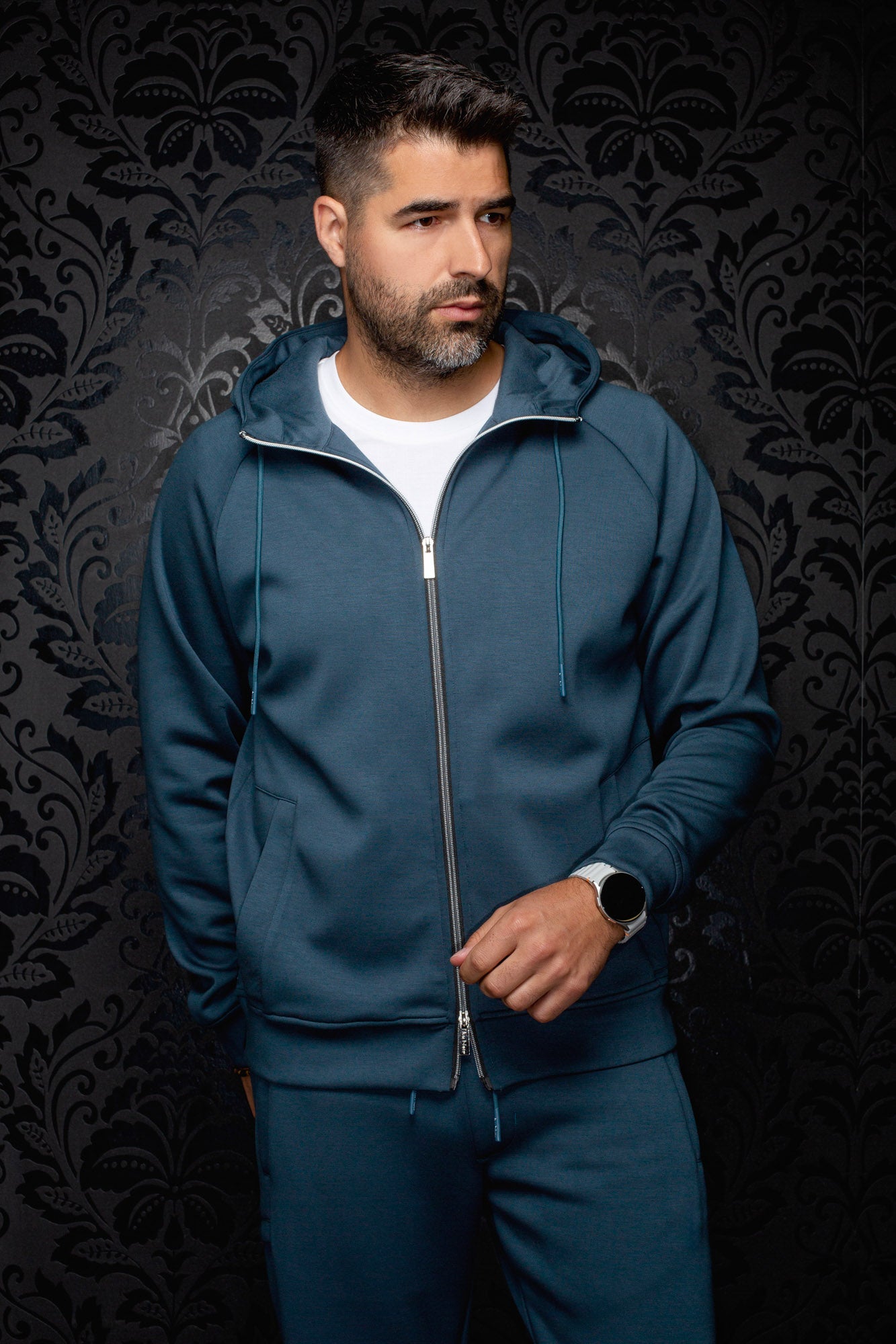 Men's teal full-zip hooded sport jacket on model, front view with drawstrings and split pockets by Au Noir