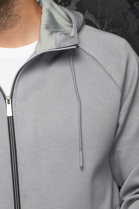 Au Noir men's light gray zip sport jacket with hood lining, black zipper tape and drawcord detail, close-up
