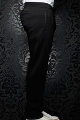 Side view of men's black jogging pants with elastic waistband, drawstring and vertical pocket detail by Au Noir