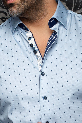Gros plan du col de chemise bleue pâle à motifs feuilles marine, boutons foncés et patte contrastante pour homme par Au Noir
