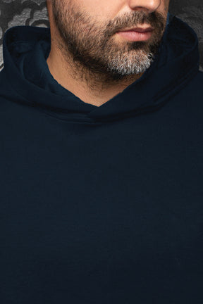 Au Noir men's navy pullover sports jacket showing the hooded neckline and smooth plain front, close-up