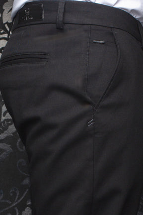 Au Noir men's black chino pants showing rear waistband, belt loop, welt pocket, and logo details, close-up
