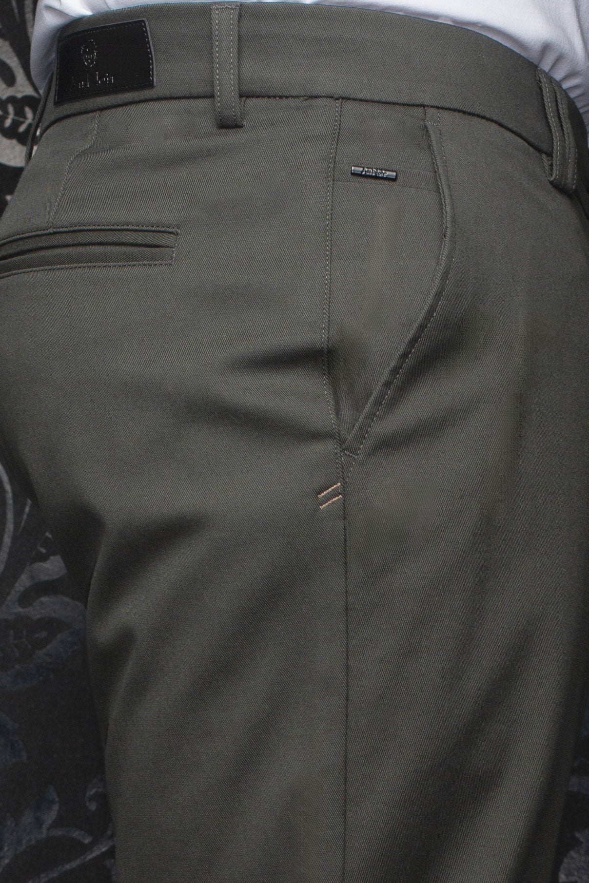 Au Noir men's olive chino pants showing rear waistband, belt loops, welt pocket, and logo trims, close-up