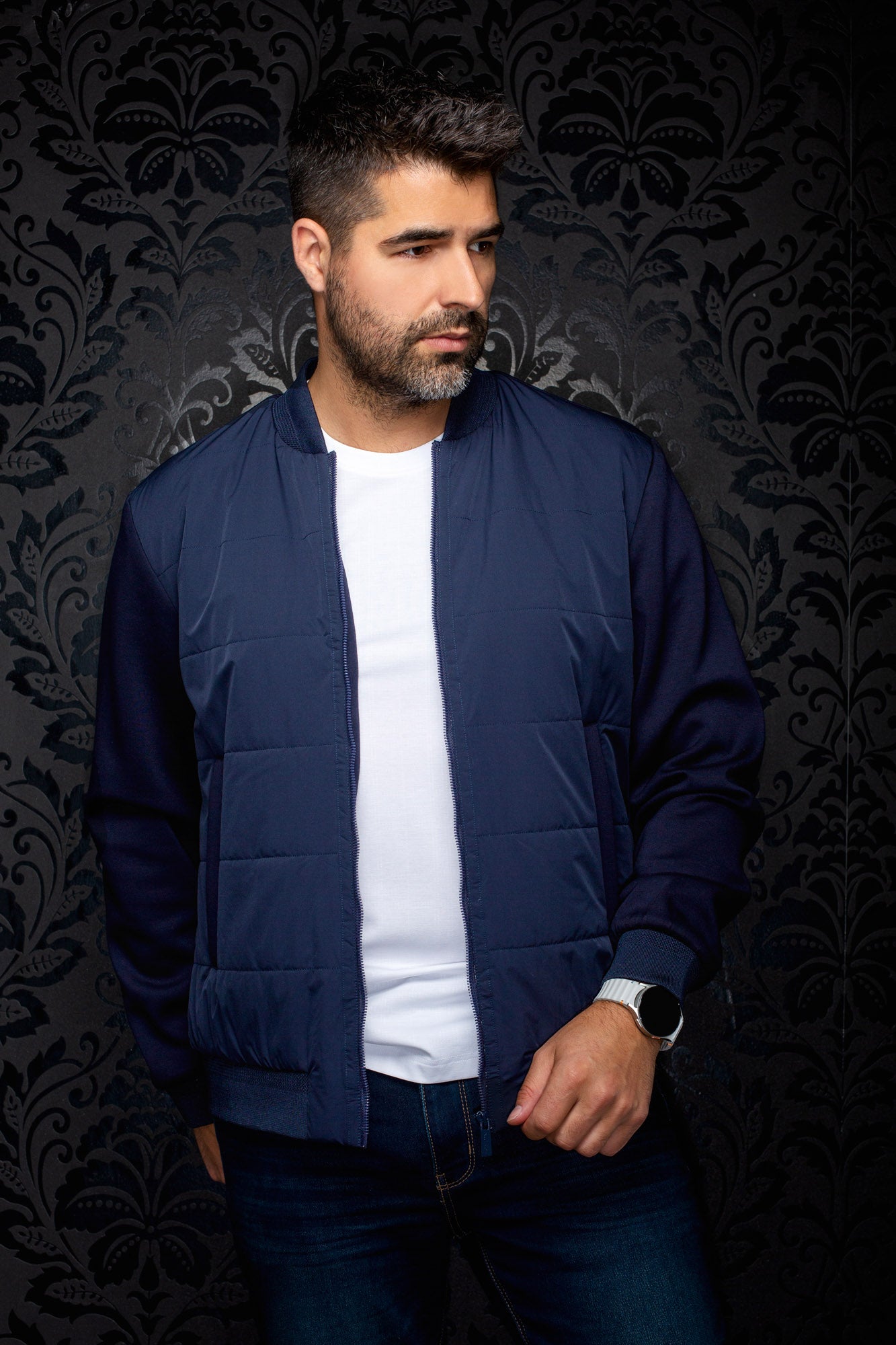 Au Noir men's navy bomber jacket on model, open front zipper, ribbed cuffs and subtle tonal chest logo