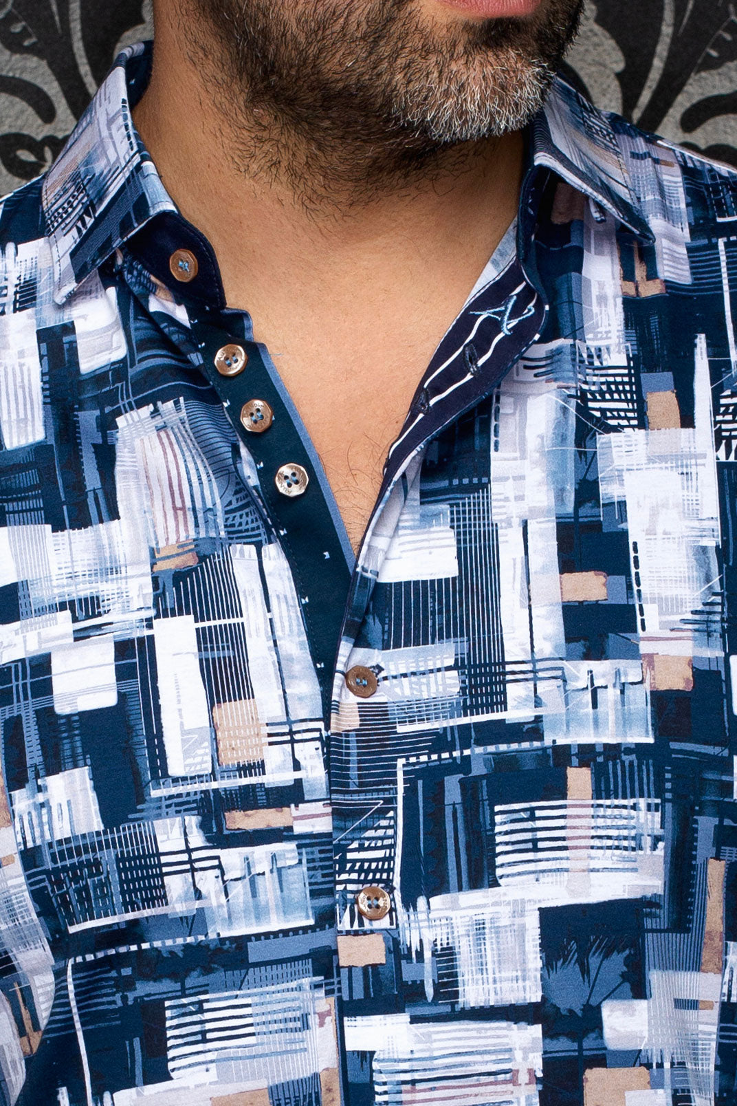 Au Noir men's navy printed button-up shirt showing collar, placket, tan buttons, and geometric print, close-up