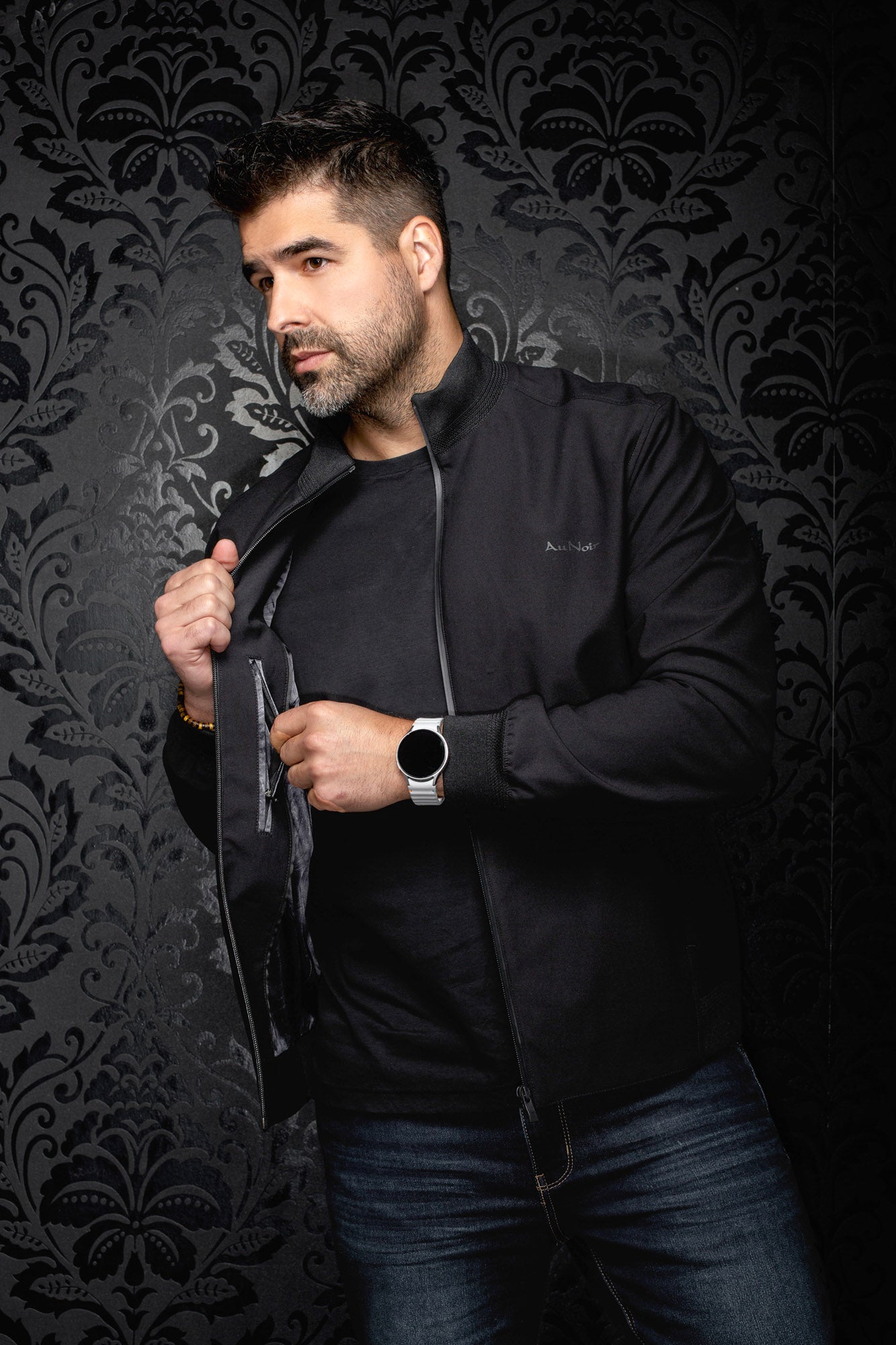 Au Noir men's angled view of black bomber jacket held open, showing dark lining and interior zip pocket, side view
