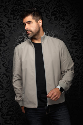 Men's angled front view of light gray bomber jacket open, with ribbed collar and tonal chest logo by Au Noir
