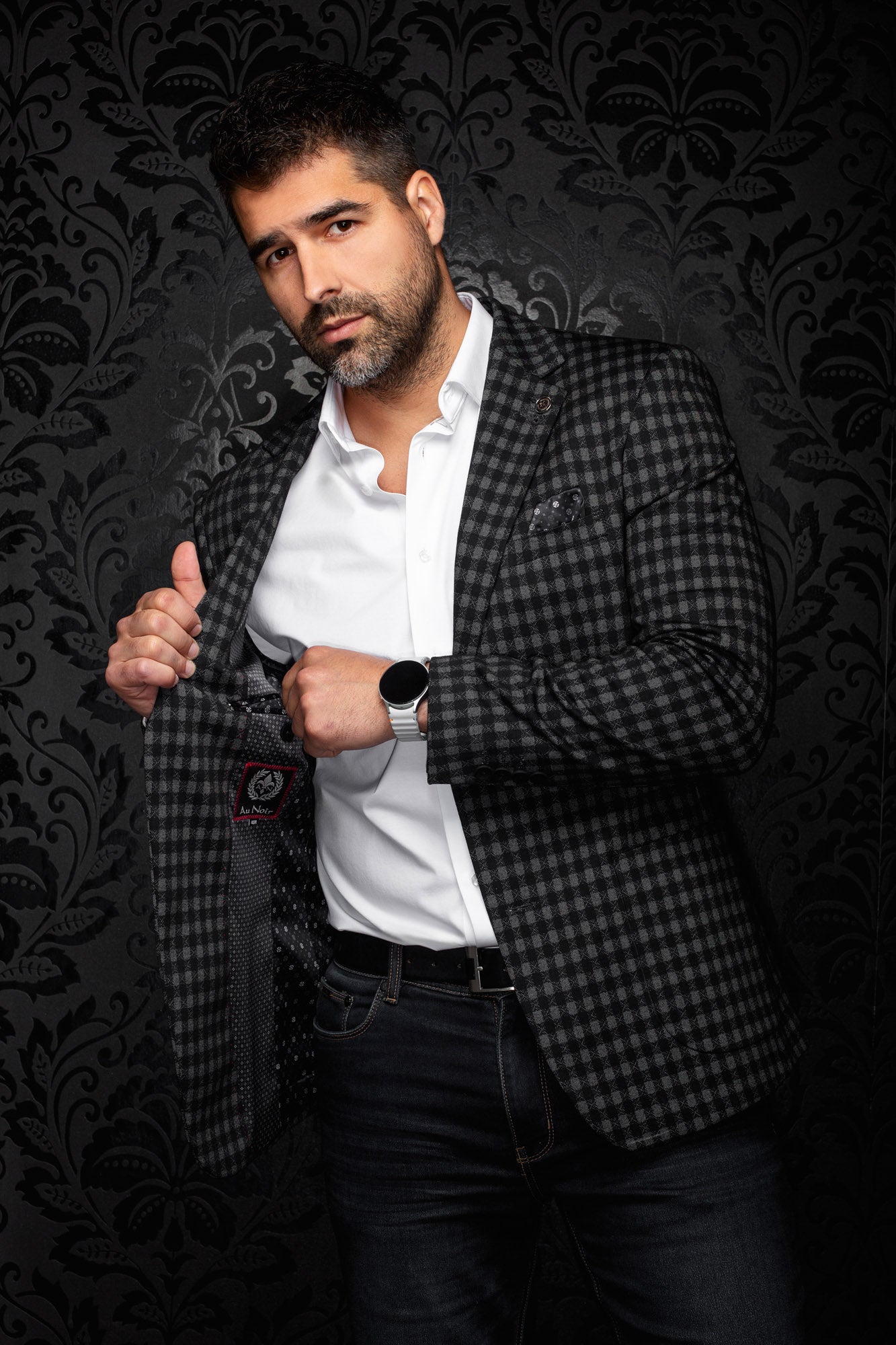 Au Noir men's angled view of black and gray check blazer opened to show dark patterned lining and label, detail view