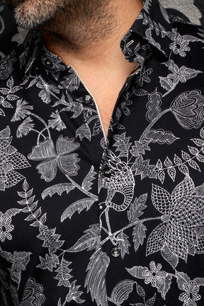 Au Noir men's collar and placket on black shirt with white floral line print and black buttons, close-up