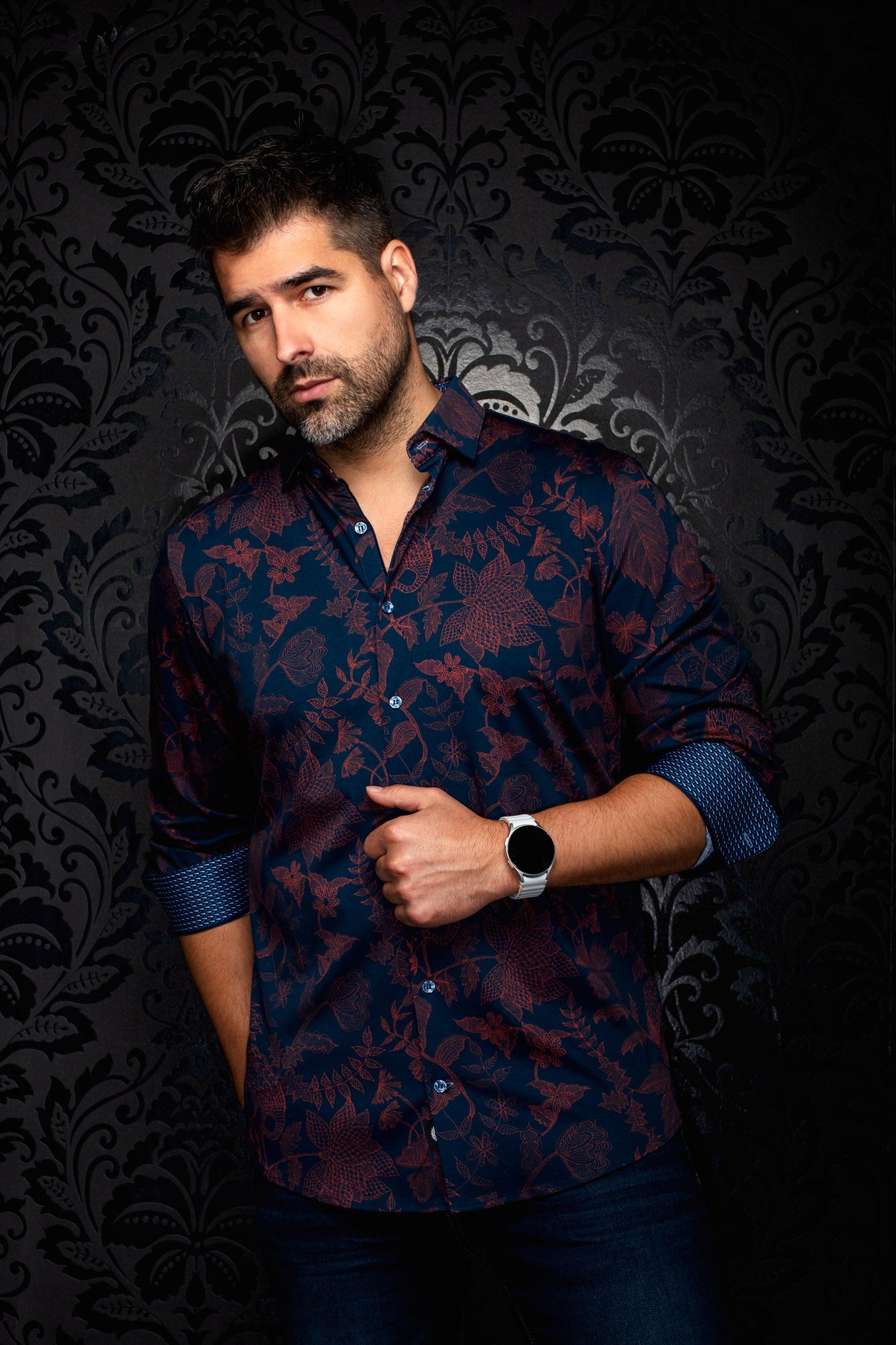 Men's angled front view of navy floral button-up shirt with rolled sleeves and blue patterned cuffs by Au Noir