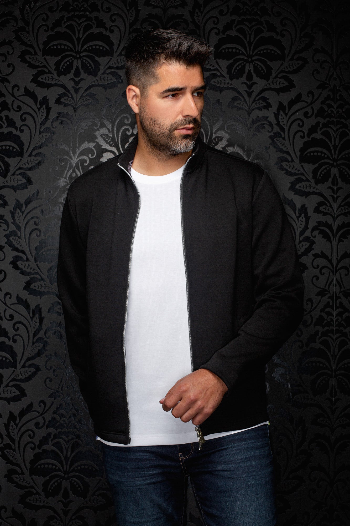 Au Noir men's angled front view of the black zip sport jacket worn open, showing the stand collar and silver zipper
