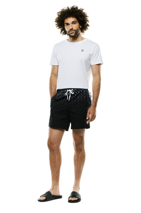 Men's full-body front view of black swim shorts with repeat bunny skull print and white drawstring by Psycho Bunny