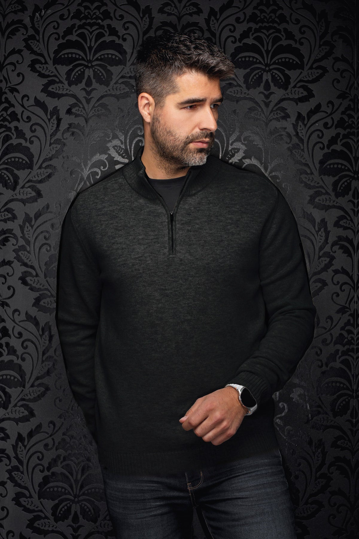 Men's black textured knit quarter-zip cashmere sweater shown from the front on a model by Au Noir