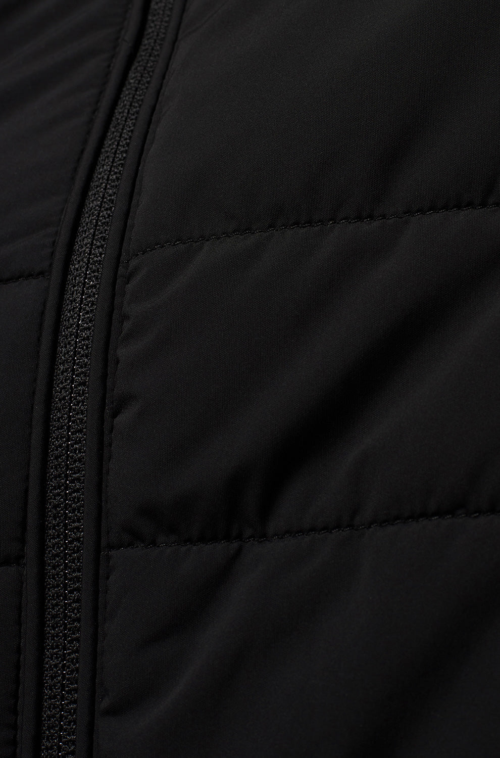Psycho Bunny men's black quilted windbreaker jacket fabric with horizontal stitching and front zipper, close-up