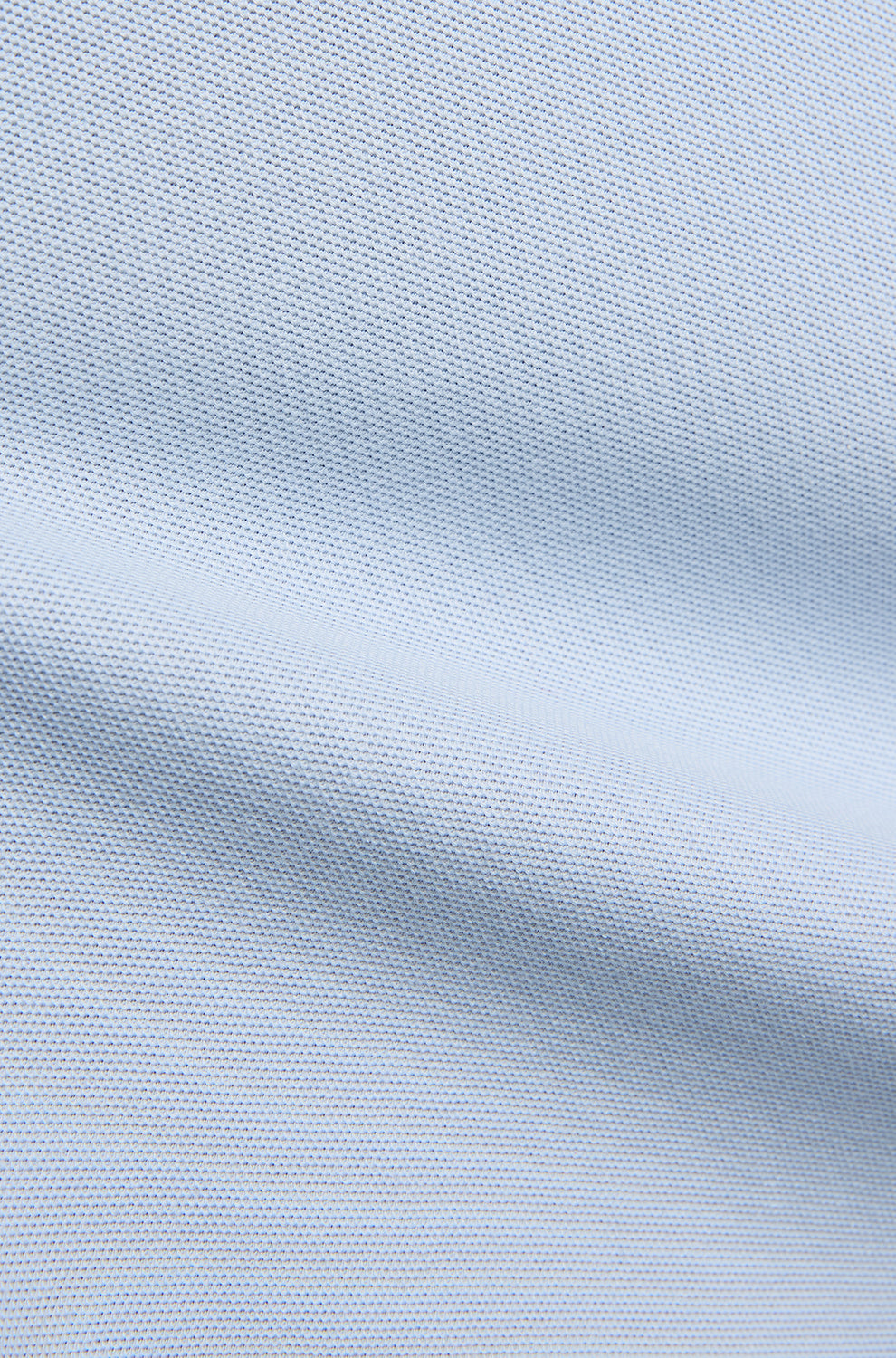 Psycho Bunny men's light blue piqué knit fabric with a seam-like fold and fine textured weave, close-up