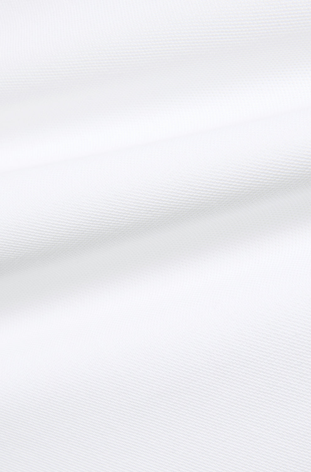 Psycho Bunny men's white textured knit fabric with subtle ridges and folds, close-up