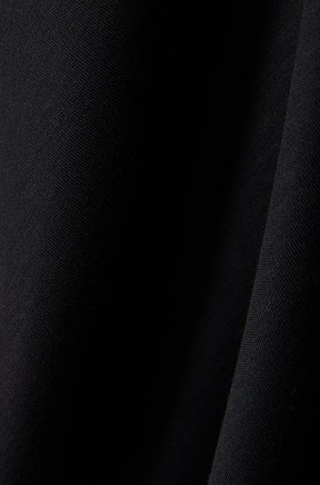 Psycho Bunny men's black short-sleeve polo shirt fabric close-up with dark seam and fine knit texture