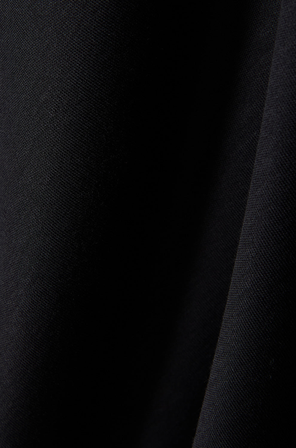 Psycho Bunny men's black short-sleeve polo shirt fabric close-up with dark seam and fine knit texture