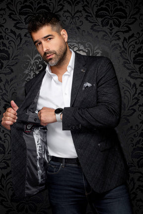 Men's angled view of a charcoal textured blazer opened to show dark patterned lining and logo label, detail view by Au Noir
