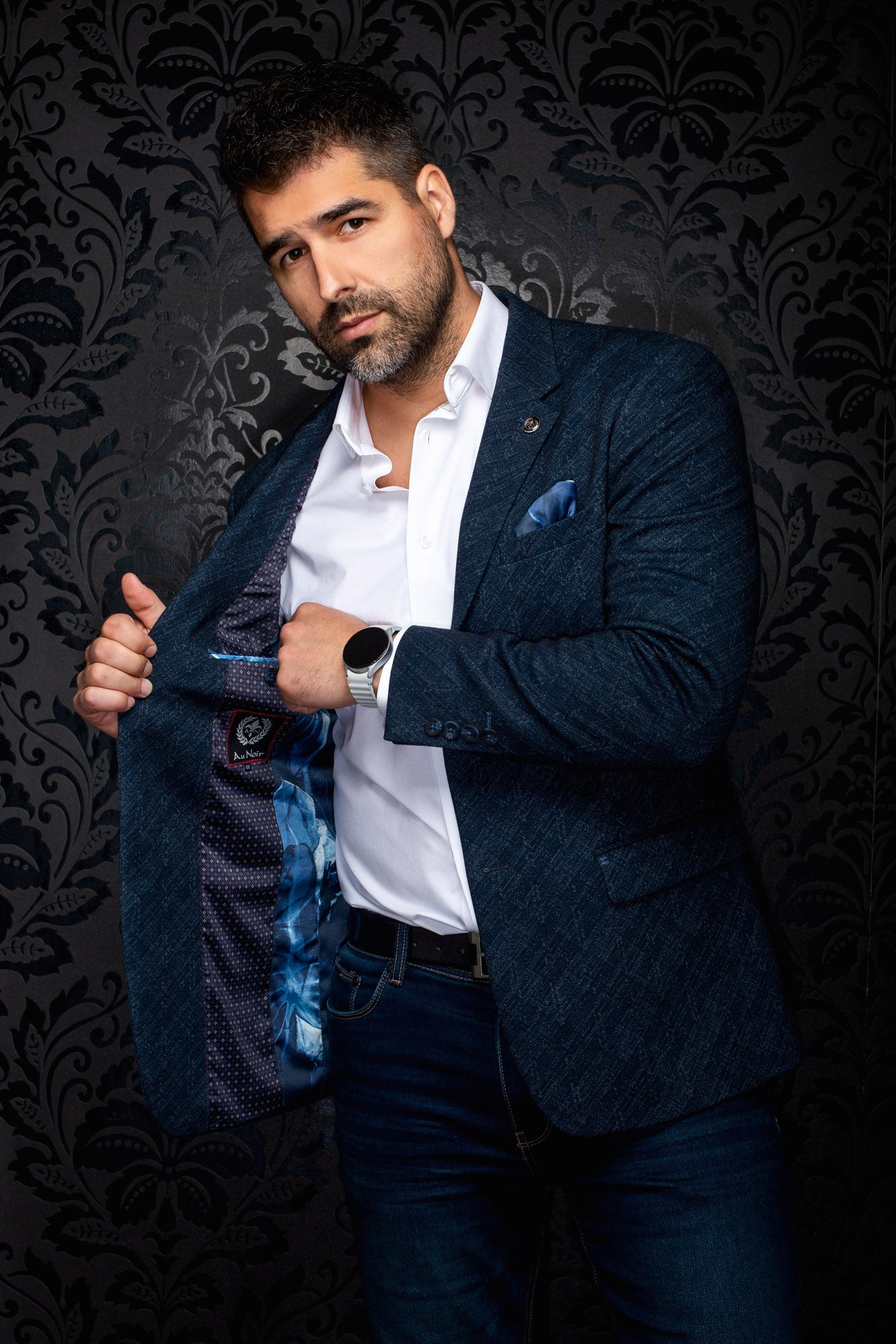 Men's navy textured blazer held open to show contrast blue patterned lining and inside label, detail view by Au Noir