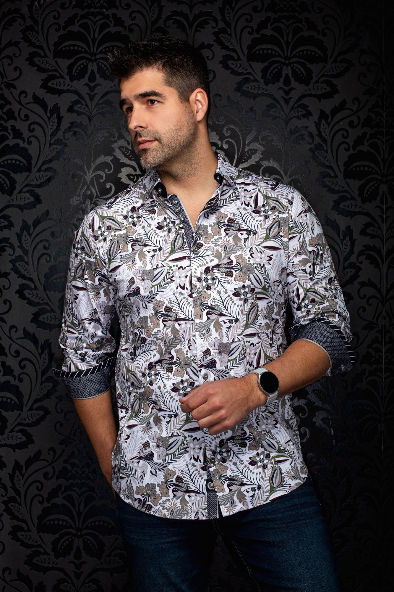 Men's angled model view of a white floral button-up shirt with rolled cuffs and dark contrast details, side view by Au Noir