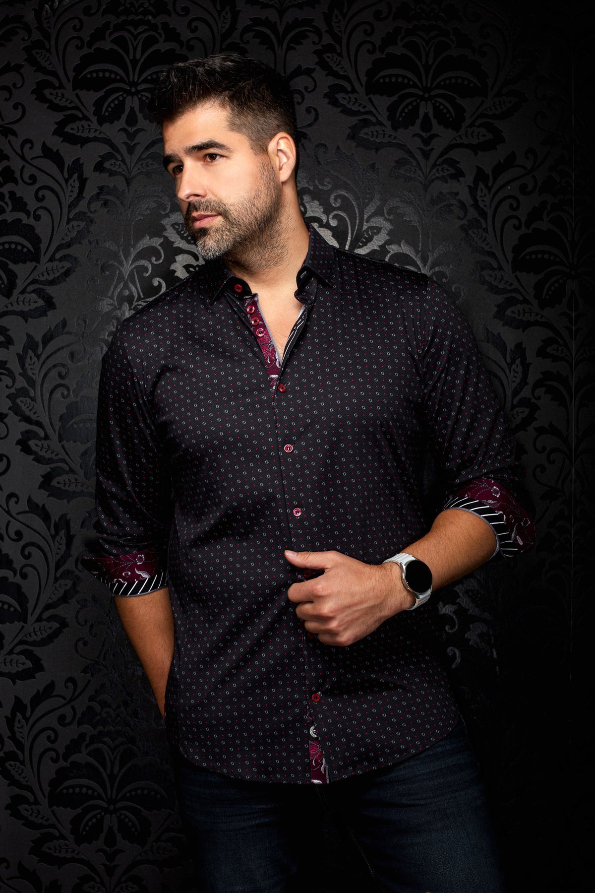 Au Noir men's angled model view of black printed button-up shirt with rolled cuffs and burgundy contrast facing, side view