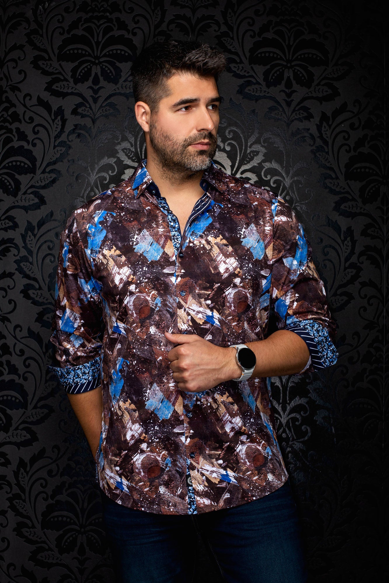 Men's brown abstract print button-up shirt on model, with blue accents and rolled contrast cuffs, front view by Au Noir