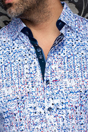 Gros plan du col de chemise florale blanche, patte marine, boutons foncés et motif bleu-rouge pour homme par Au Noir