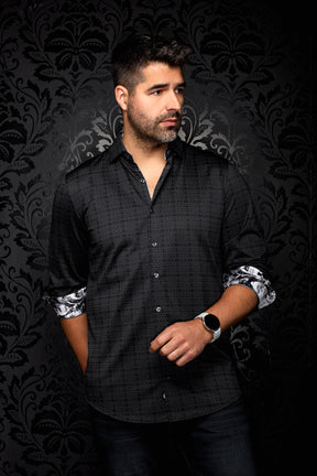 Au Noir men's angled model view of black patterned button-up shirt with rolled cuffs showing contrast print, side view