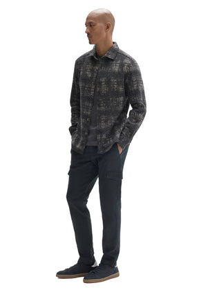 Men's angled full-body view of charcoal plaid overshirt worn open over a dark T-Shirt, side view by Robert Barakett