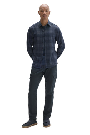 Robert Barakett men's full-body front view of navy plaid long sleeve overshirt worn open over a dark T-Shirt