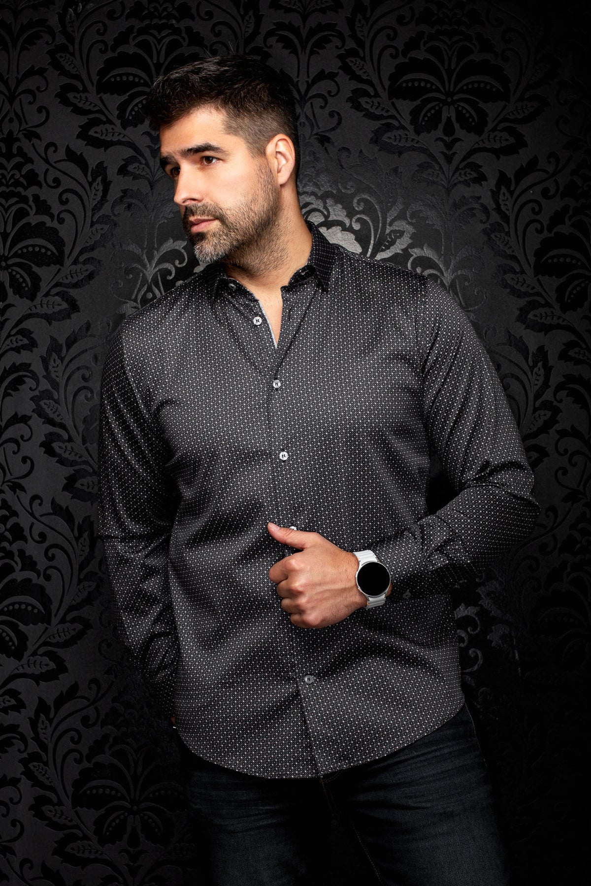 Men's angled front view of black micro-geometric button-up shirt with long sleeves and curved hem by Au Noir